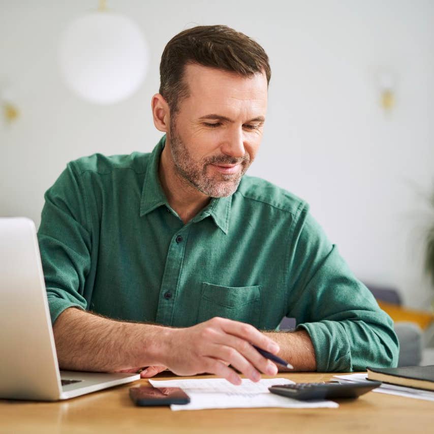 Man at home sitting with laptop and documents examining home finances