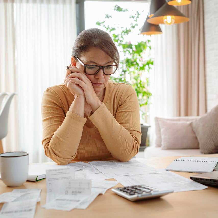 Mature woman contempling bills and tax papers at home
